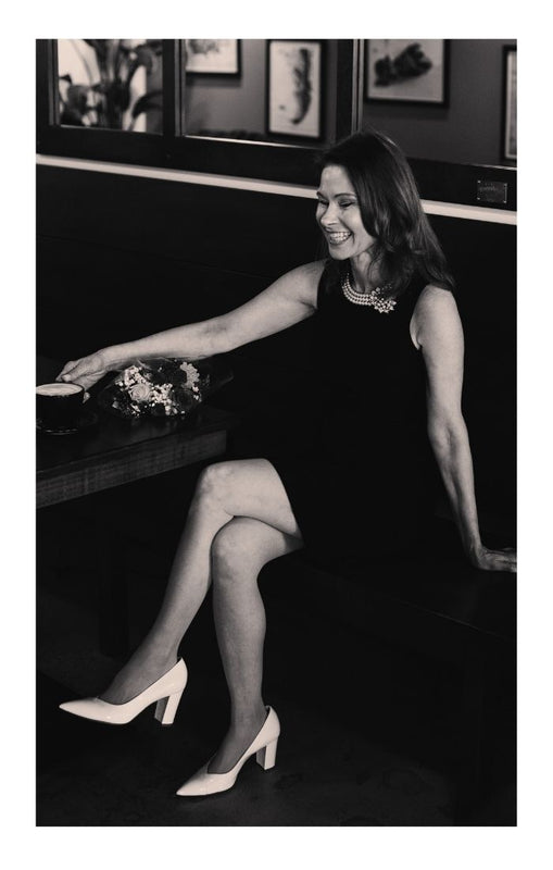 woman wearing a black dress and white luna selene pumps 