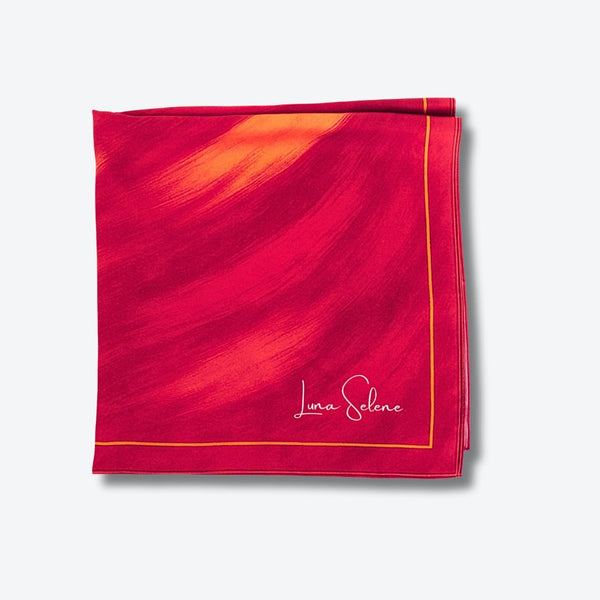 Red and pink Luna Selene silk scarf on a light grey background. 